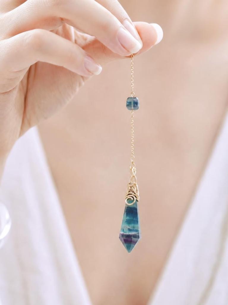 Rainbow fluorite pendulum necklace held by hand
